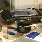View of studio with hot skillet on table and pots of encaustic paint